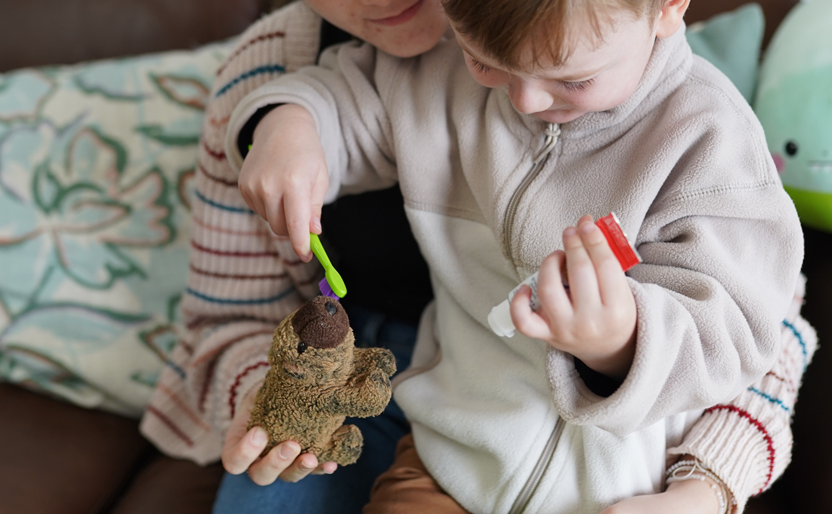 Park Orchards Dental | Young child pretending to brush a stuffed animal's teeth with a toothbrush and toothpaste